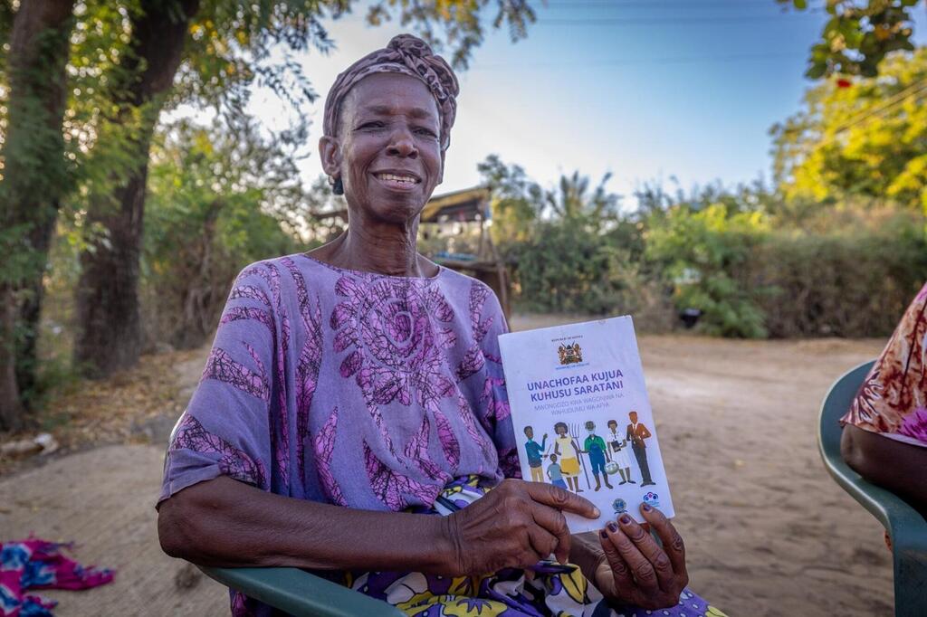 Une femme du Kenya tient une brochure sur le cancer du col de l'utérus de l'OMS.